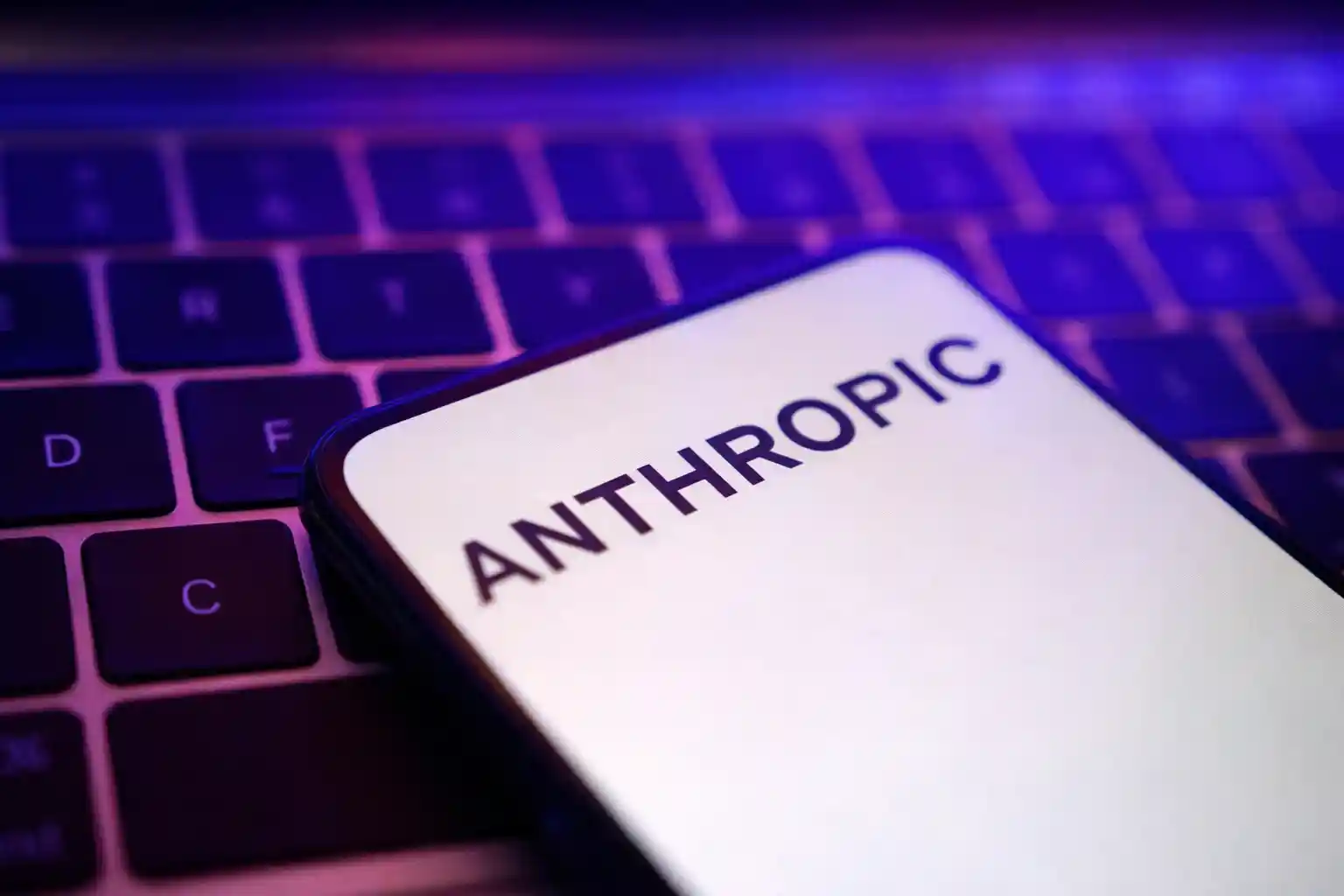 Anthropic logo displayed on a smartphone screen over a computer keyboard