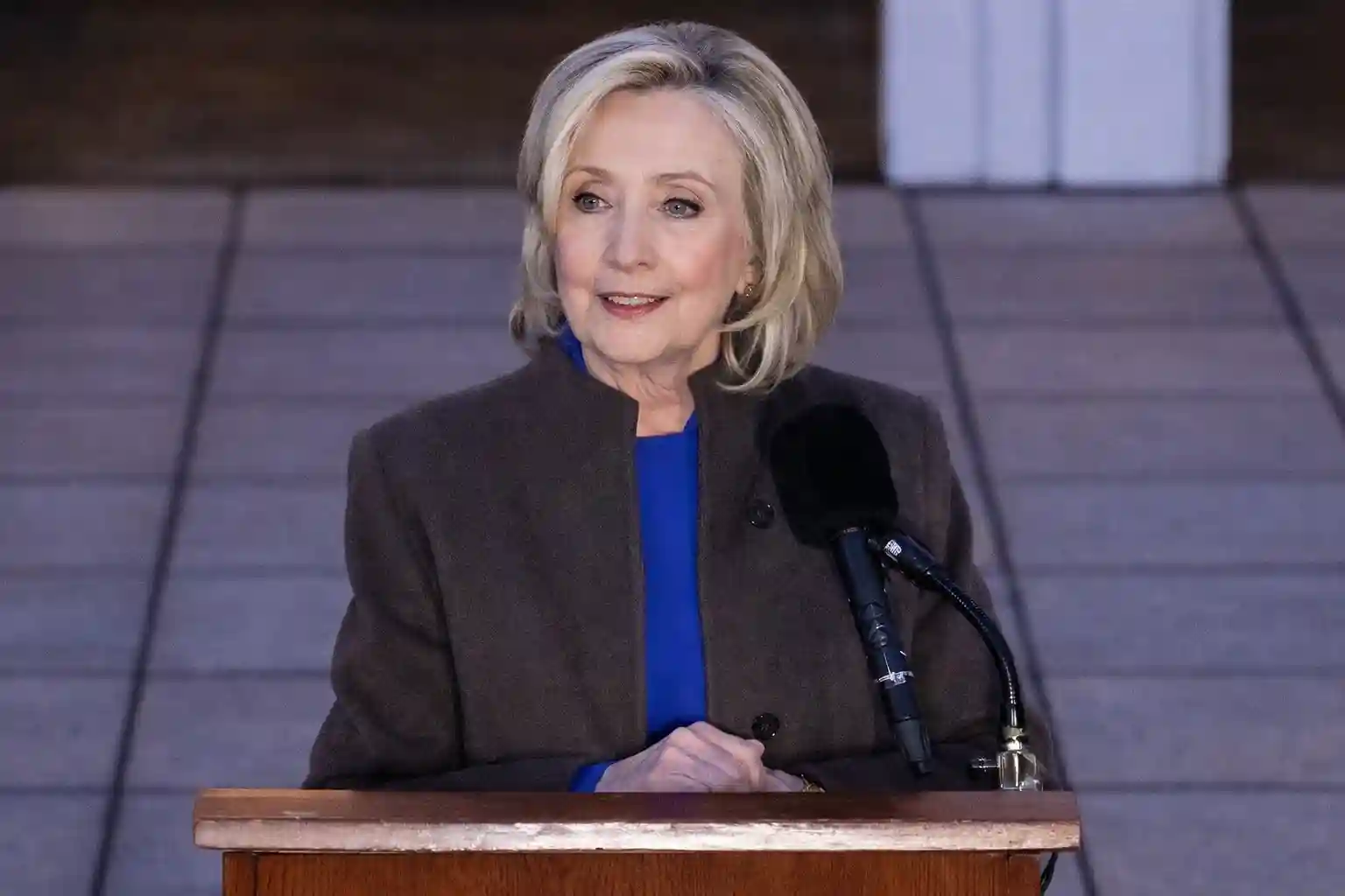 Hillary Clinton speaking at a podium after a closed-door House Oversight Committee deposition on the Jeffrey Epstein investigation in Chappaqua, New York.