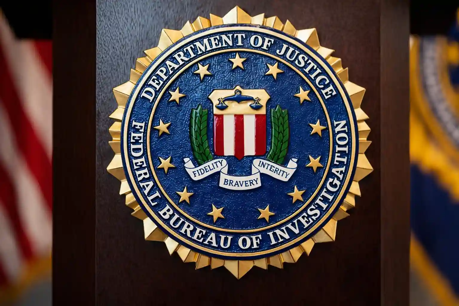 Official FBI seal displayed on a podium with U.S. flags in the background