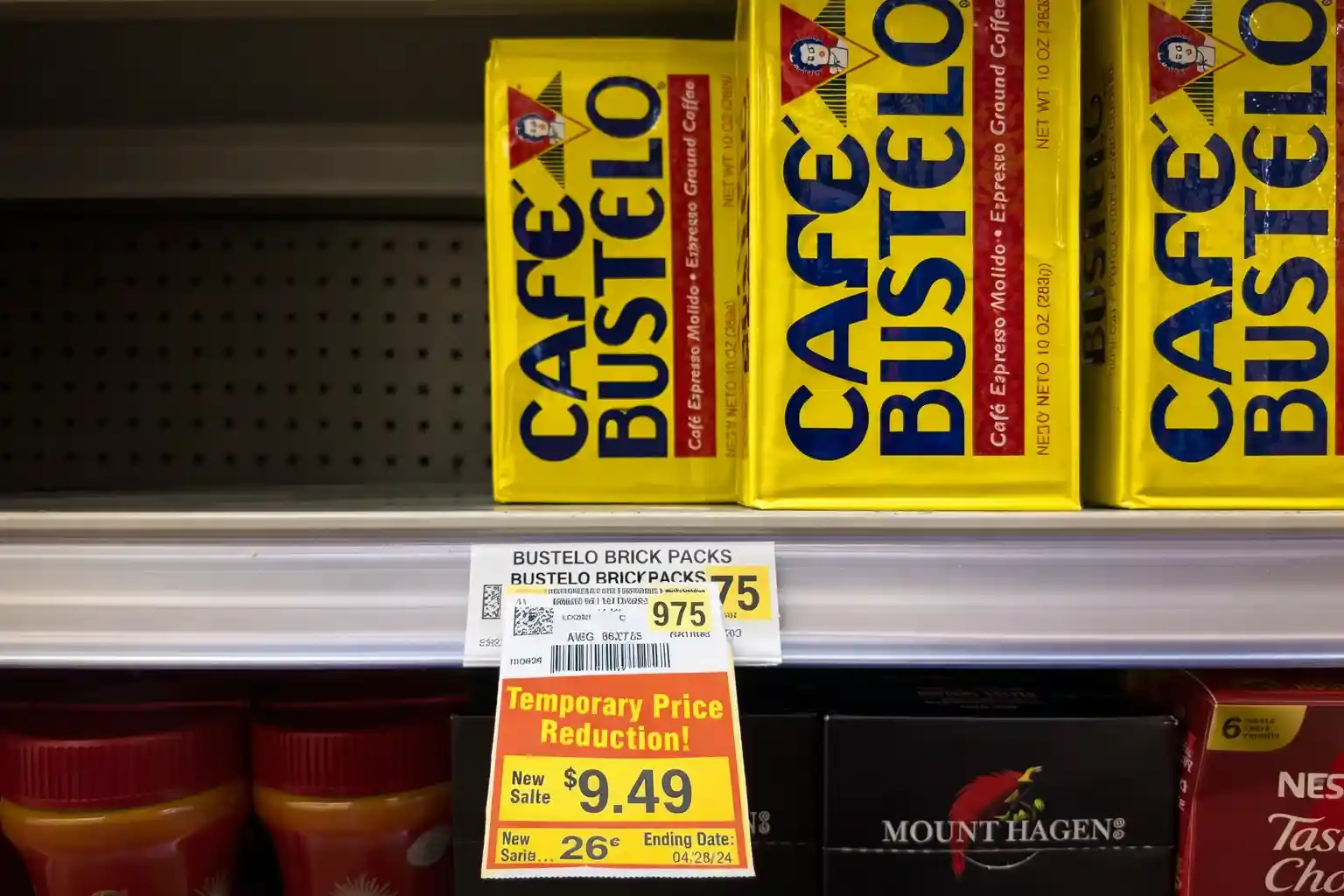 Cafe Bustelo coffee packs on a supermarket shelf with a temporary price reduction sign.