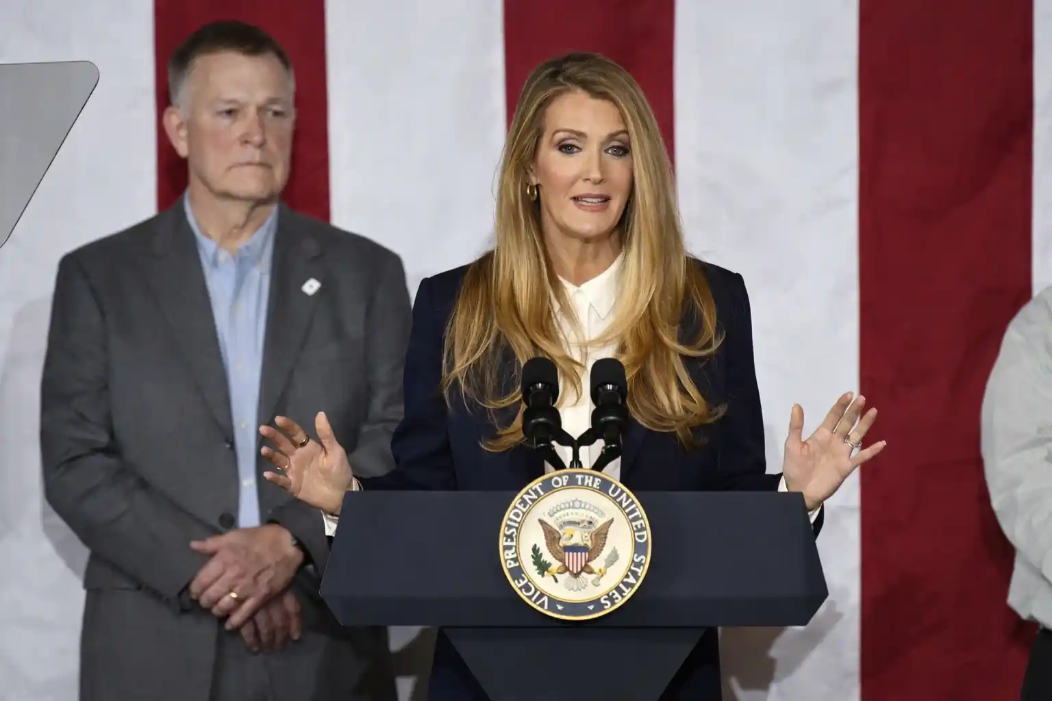 SBA Administrator Kelly Loeffler speaks at a podium with U.S. flag backdrop during a public address.