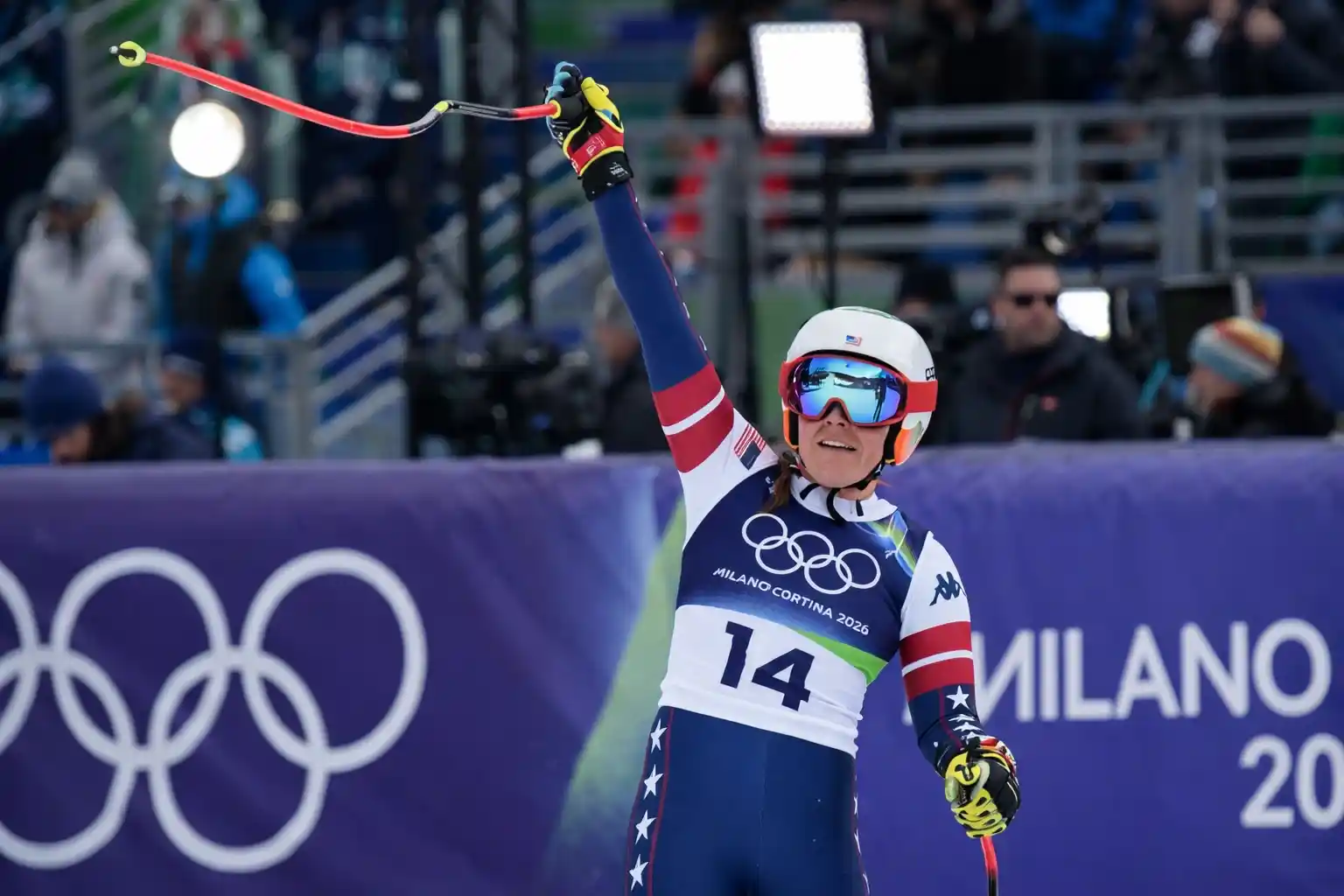Mikaela Shiffrin celebrating after crossing the finish line in a slalom race at the Milan-Cortina Olympics.