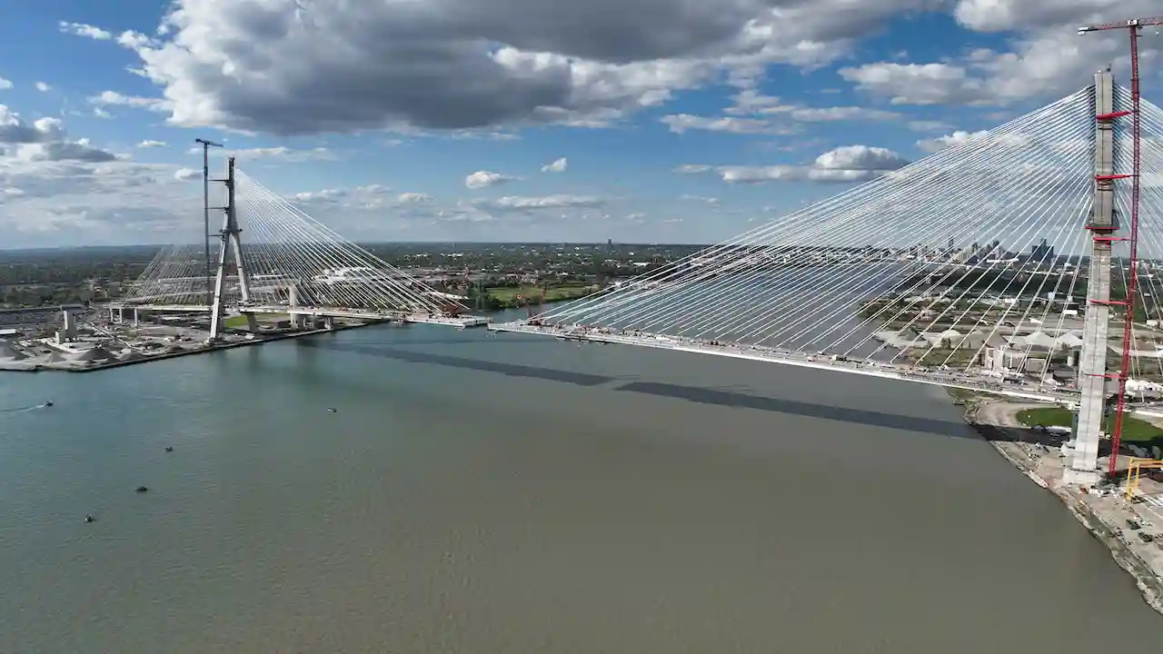 Aerial view of the Gordie Howe International Bridge with cable-stayed towers and the Detroit skyline.