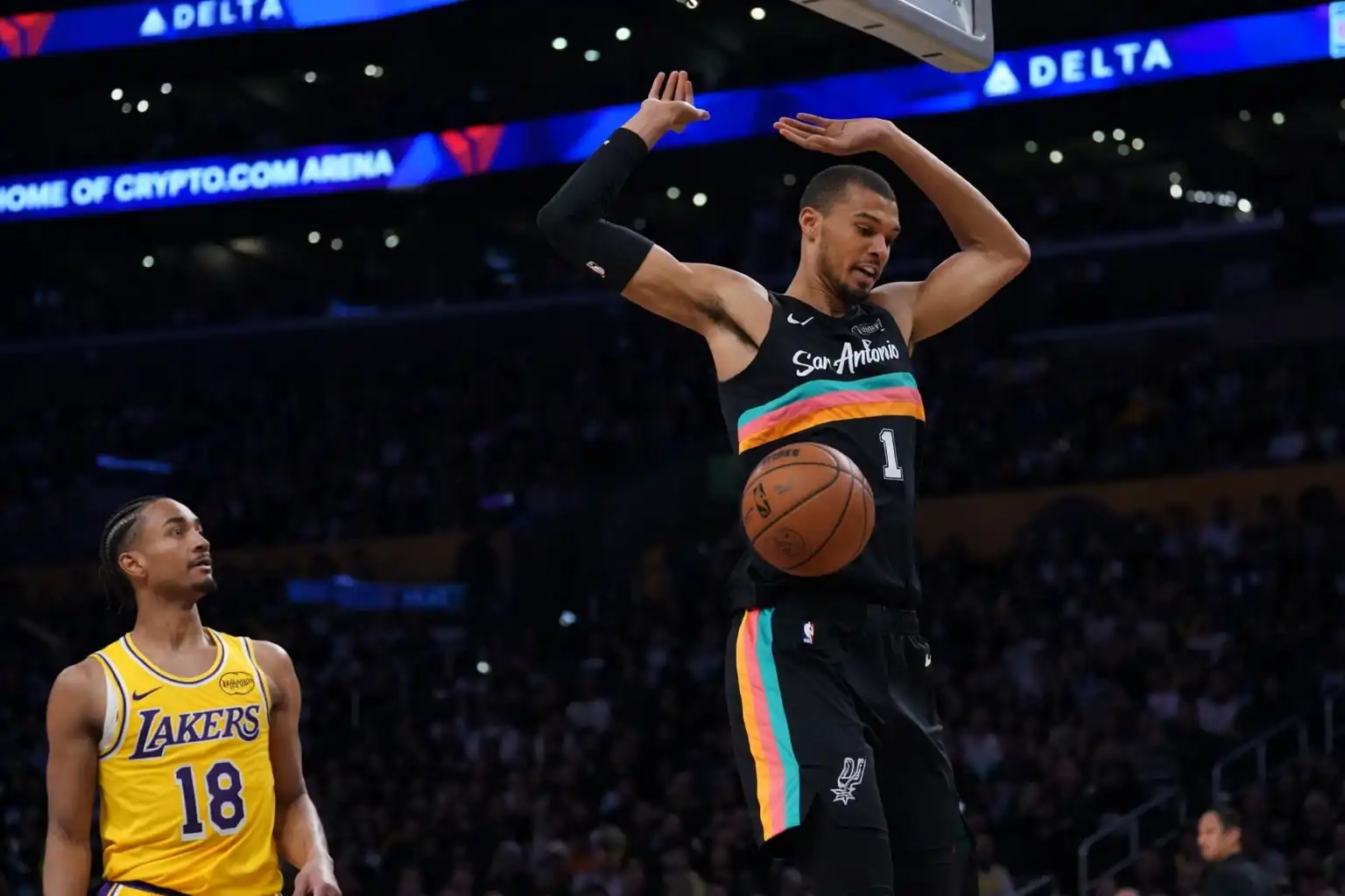Victor Wembanyama celebrating after a dunk, with his teammate watching in the background during the Spurs vs Lakers game.